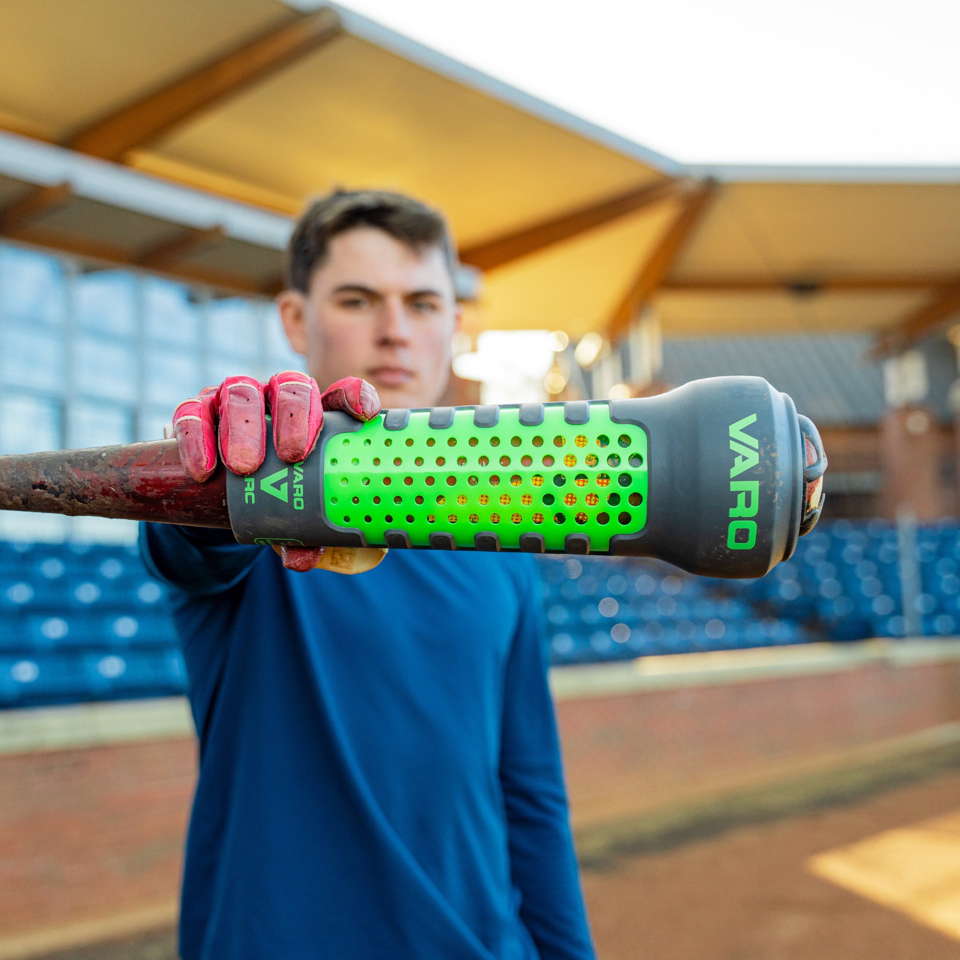 person holding a green and graphite colored Varo ARC Bat Weight 12 Oz