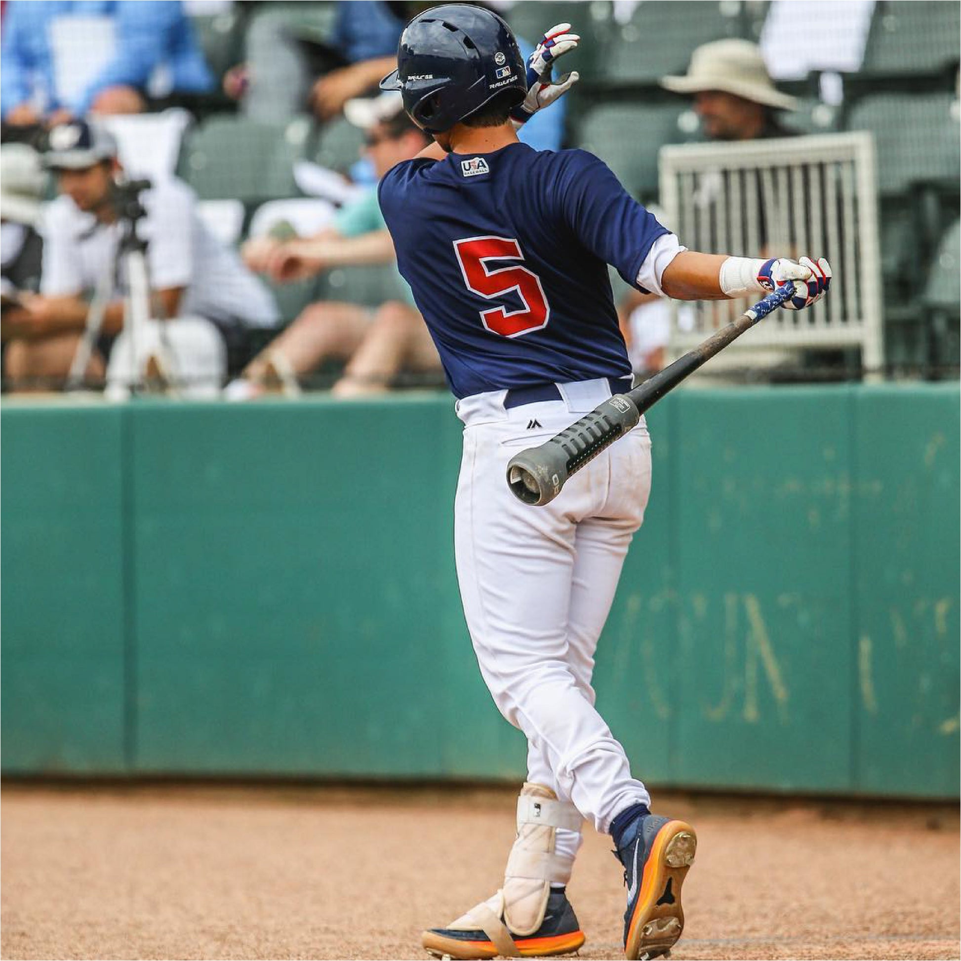 Baseball player in uniform with number 5 holding a bat with Varo ARC Bat Weight 12 Oz on bat, on a field