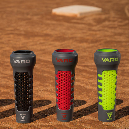 Three Varo ARC Bat Weight 12 Oz  in black, red, and hyper green on a baseball field background