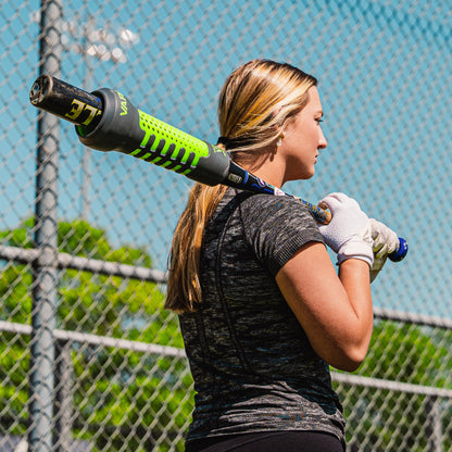 Woman holding a baseball bat with Varo ARC Bat Weight 12 Oz on it, with a fence and blue sky in the background
